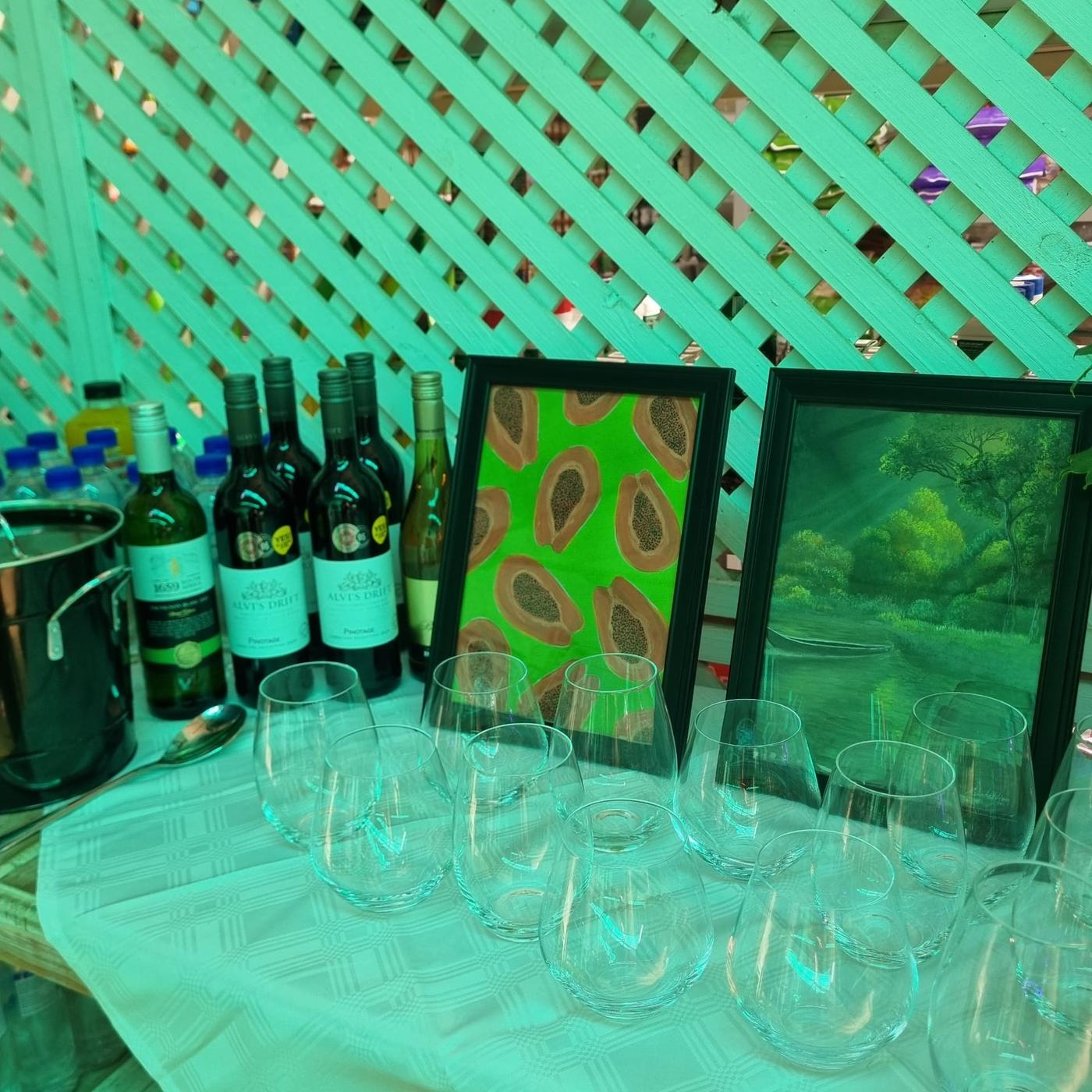 Wine, glasses and framed artwork styled on the drinks table at the Women's Day celebration