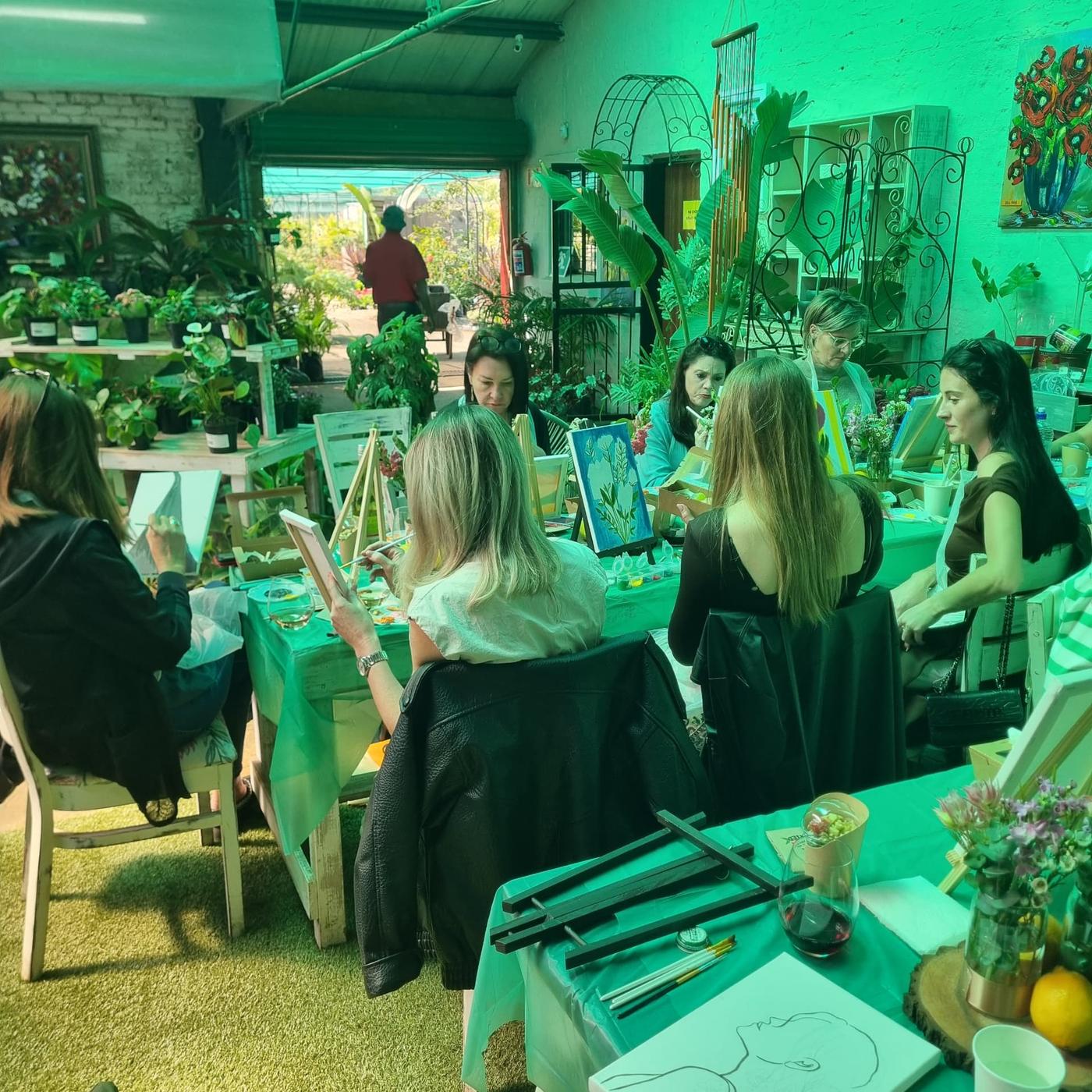 Guests painting their Strawberry Pot canvases together in the garden venue on Women's Day 2026